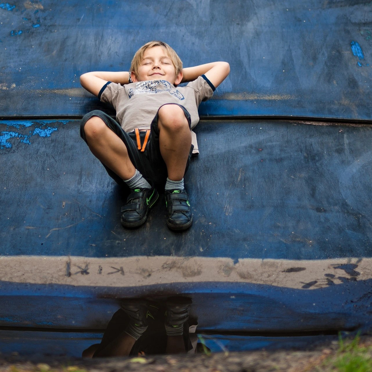 Photo d'un enfant allongé sur le dos, rêveur et heureux